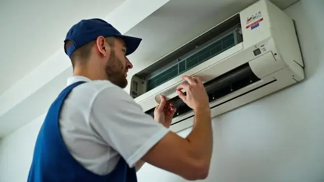 Professional HVAC technician servicing air conditioning unit
